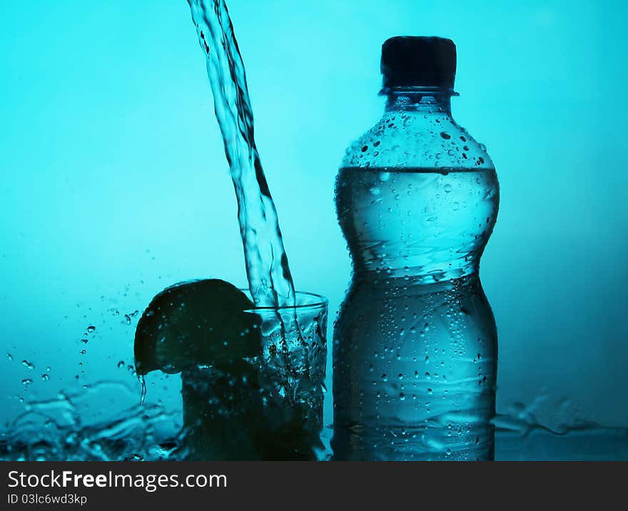 Silhouette of bottle and glass with water splashes