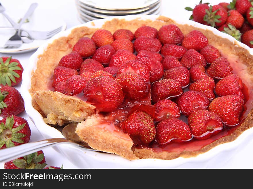 Strawberry Tart, with a portion being served, on a white background