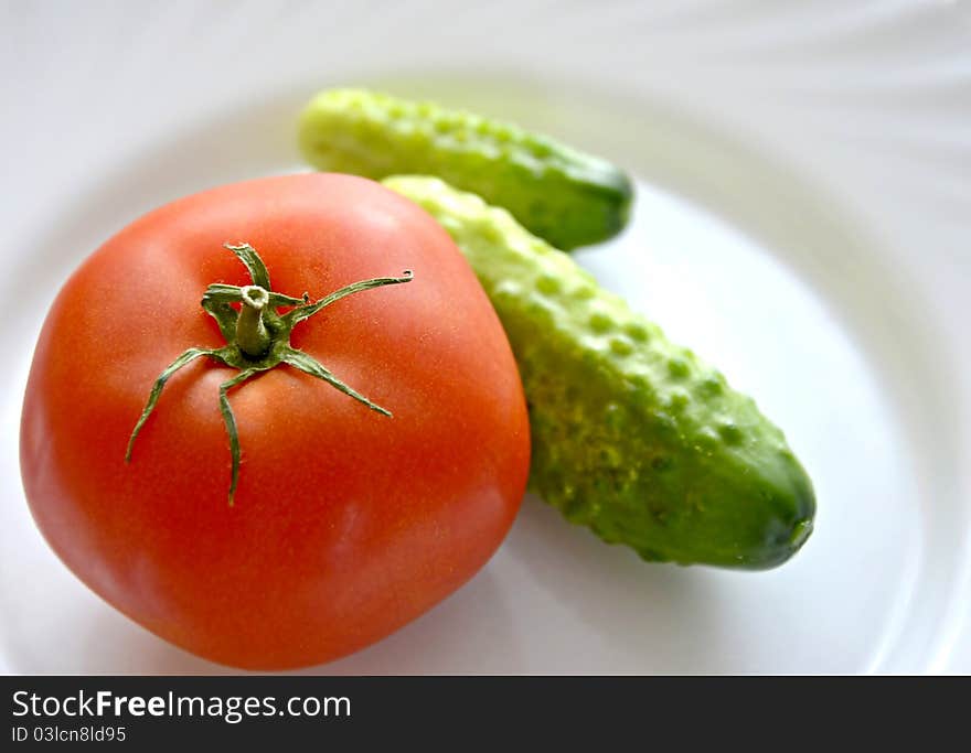 Tomato and cucumbers on white plate