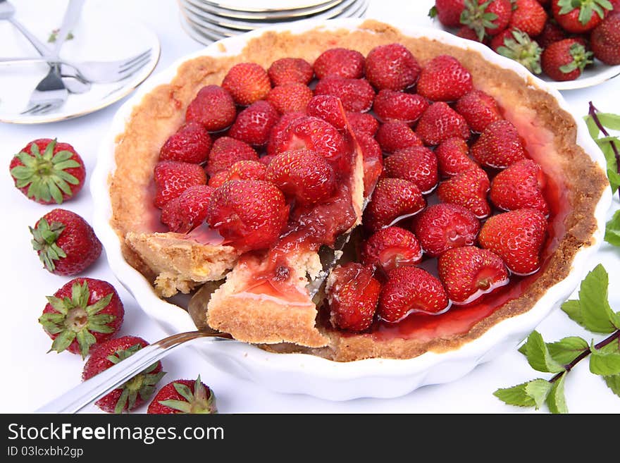 Strawberry Tart, with a portion being served, on a white background