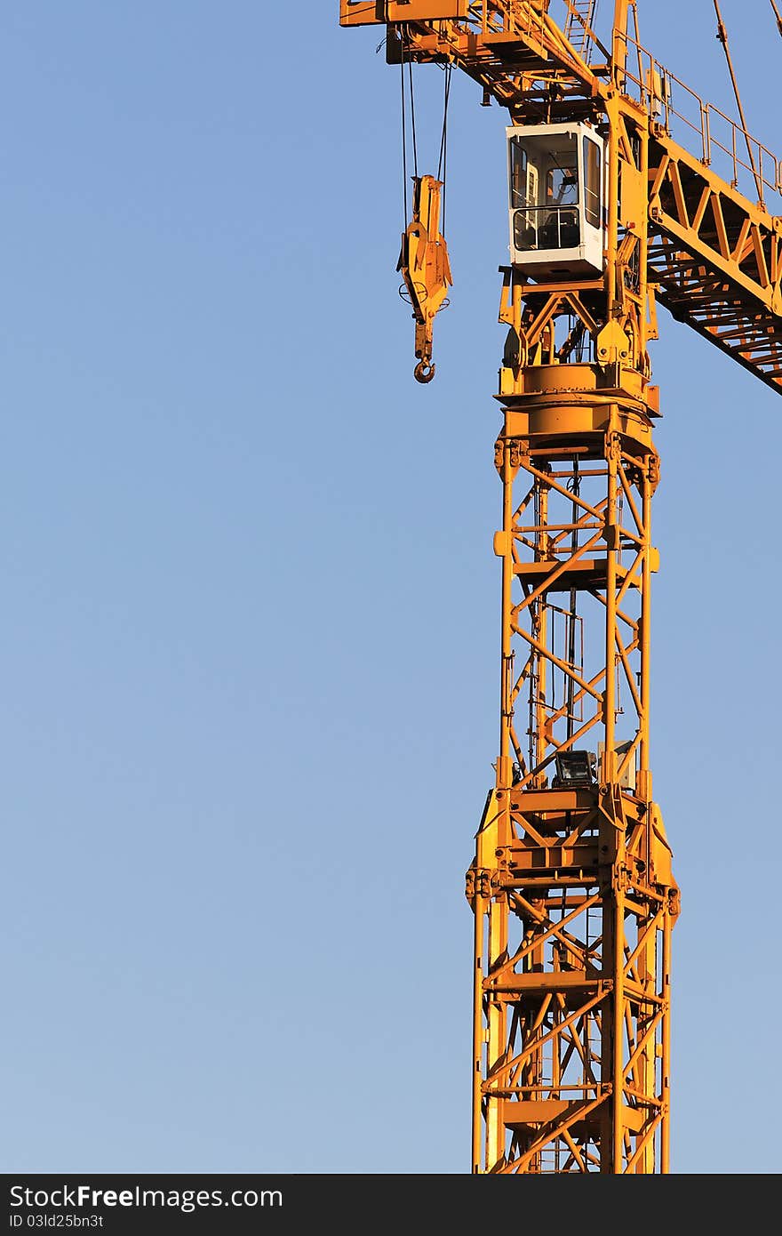 Yellow crane on building site and blue sky. Yellow crane on building site and blue sky