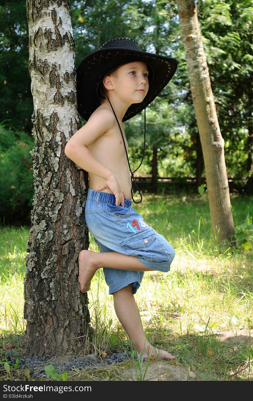 Boy in cowboy hat near the birch. Boy in cowboy hat near the birch