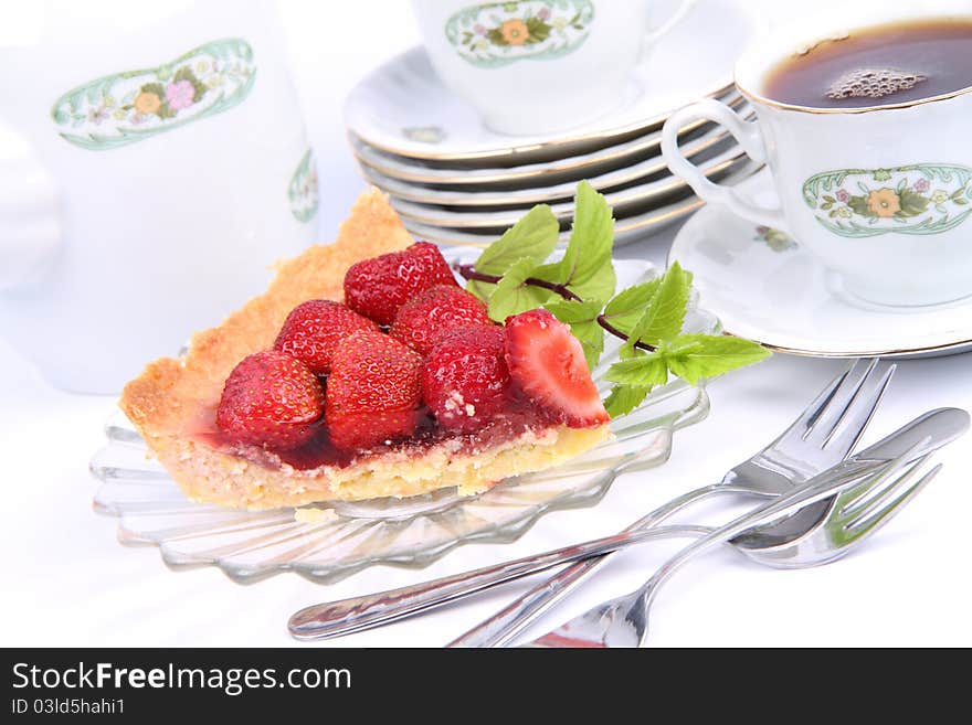 Strawberry tart, fruits, mint twig and a cup of tea