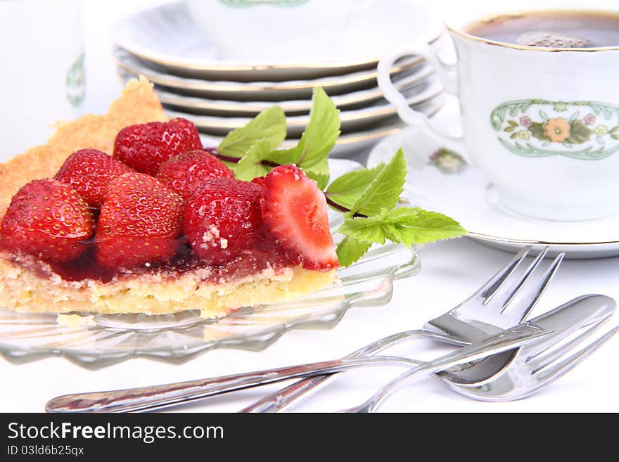 Strawberry tart, fruits, mint twig and a cup of tea