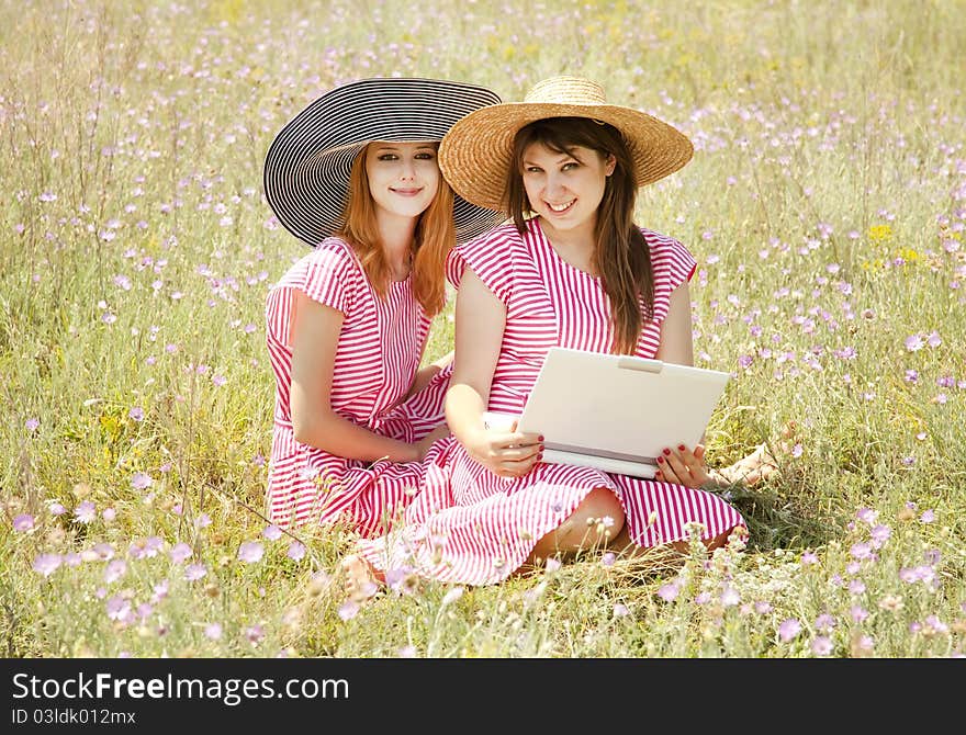 Girls at contryside with notebook.