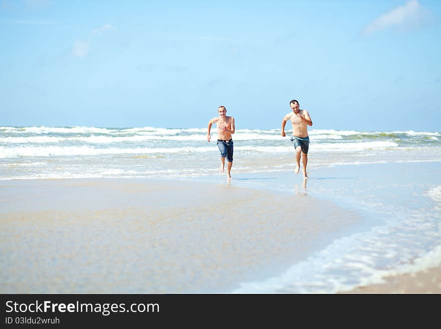 Two mans a running on the beach