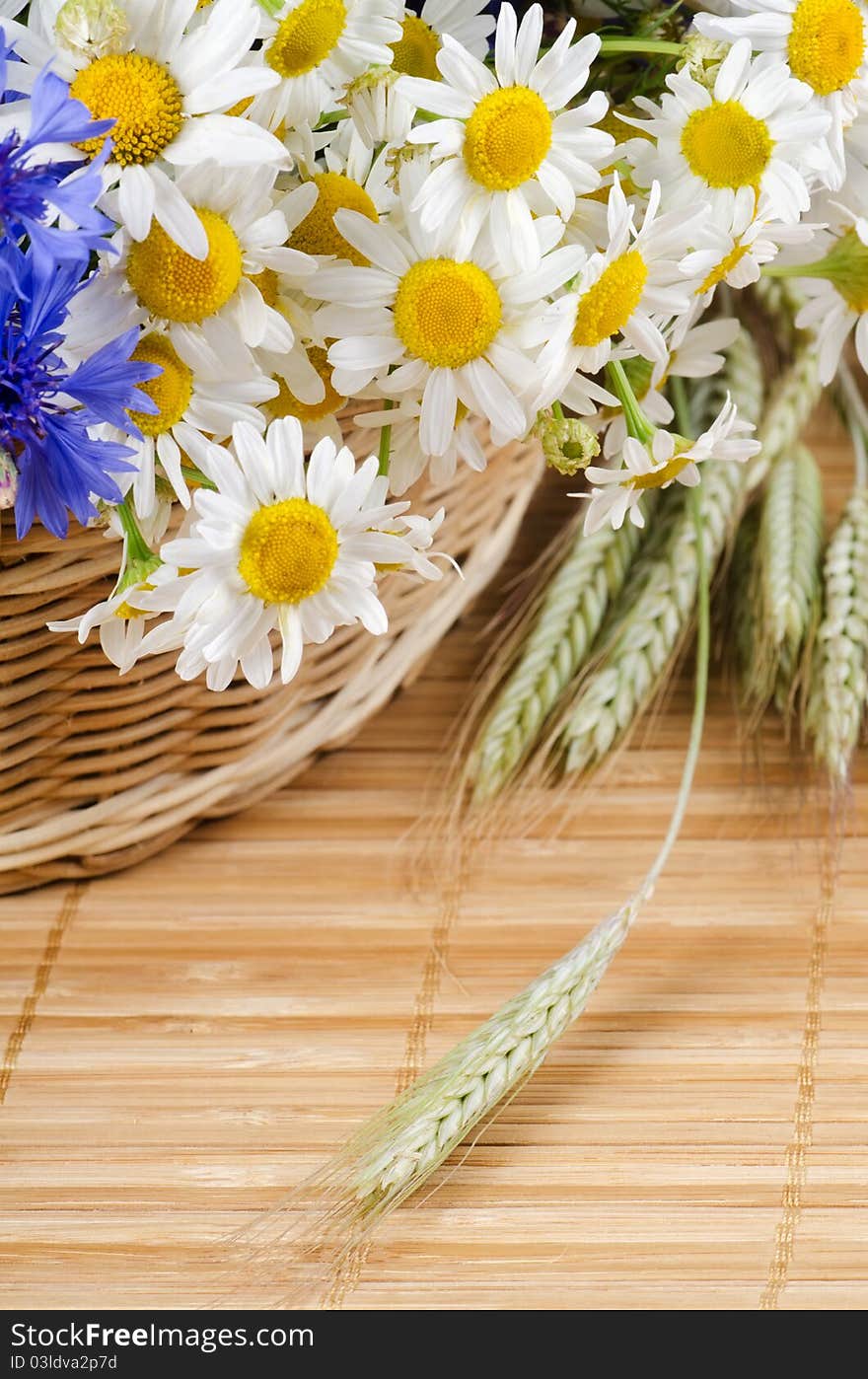 Beautiful flowers in a basket on bamboo rug