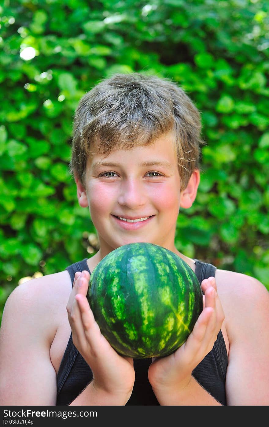 Boy holding watermelon while holding it with both hands. Boy holding watermelon while holding it with both hands