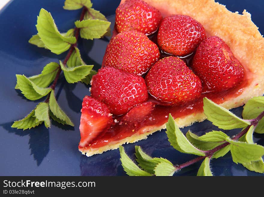 Piece of Strawberry Tart decorated with mint twigs