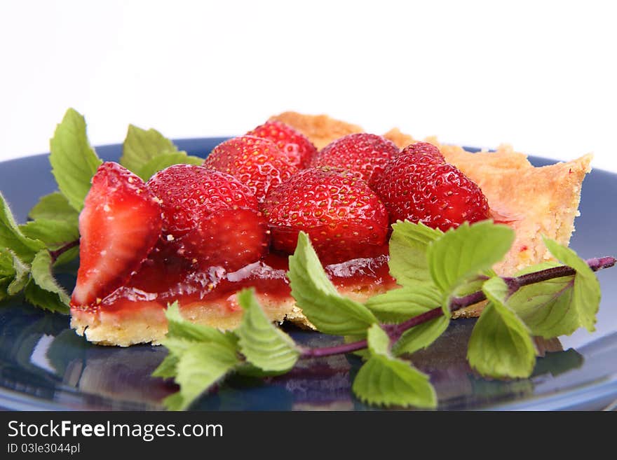 Piece of Strawberry Tart decorated with mint twigs