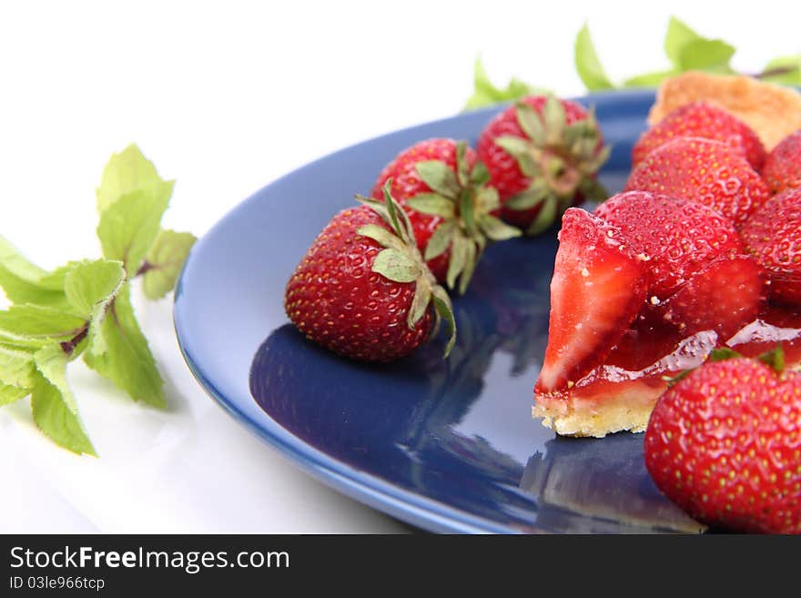 Piece of Strawberry Tart decorated with strawberries and mint