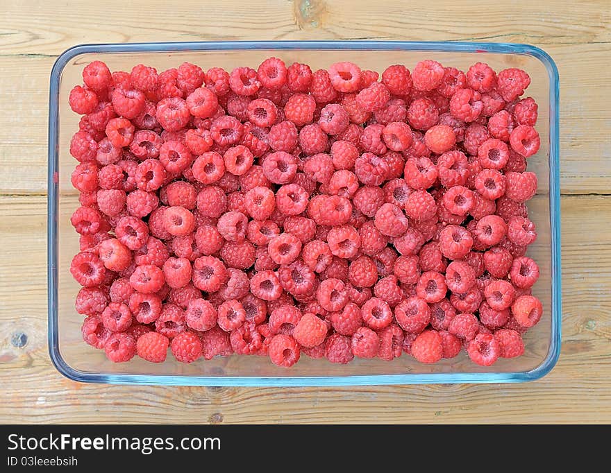 Raspberry. Raspberries in a glass pan. Raspberry on a wooden table.