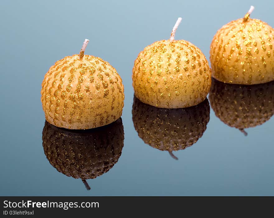 Three xmas gold candles on a mirror