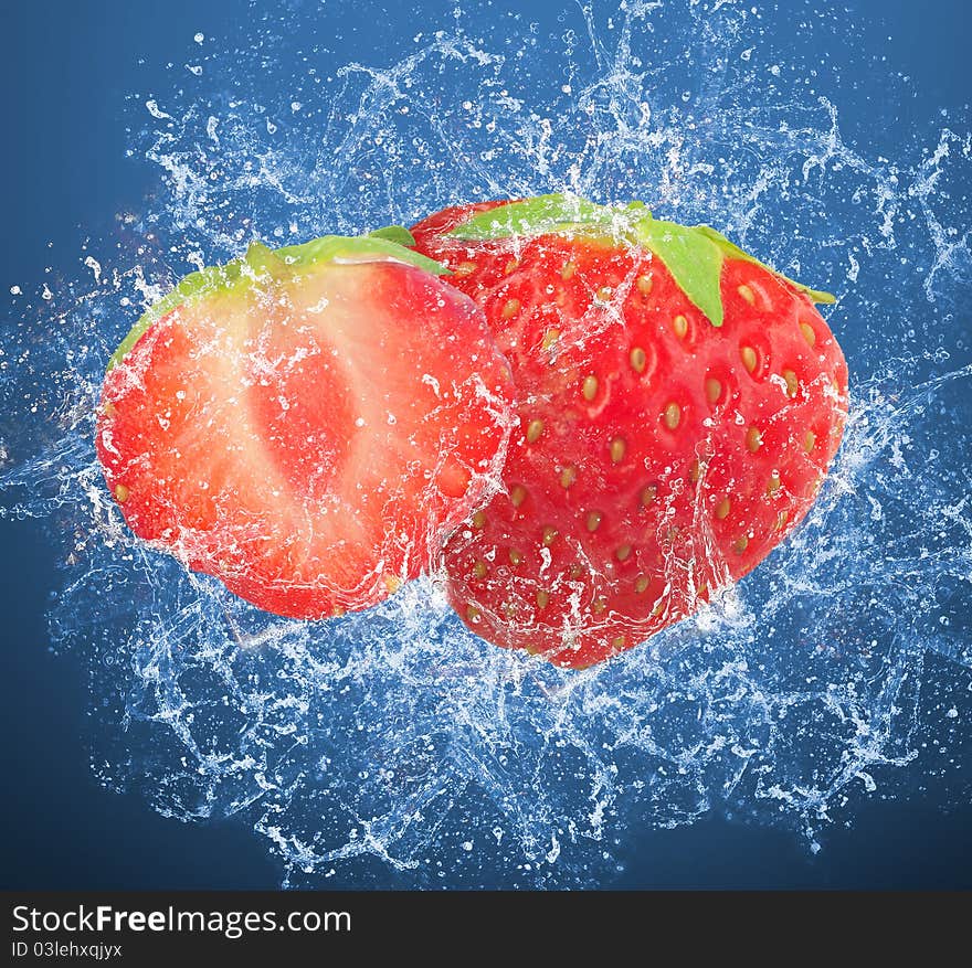 Fresh strawberries in a spray of water on blue