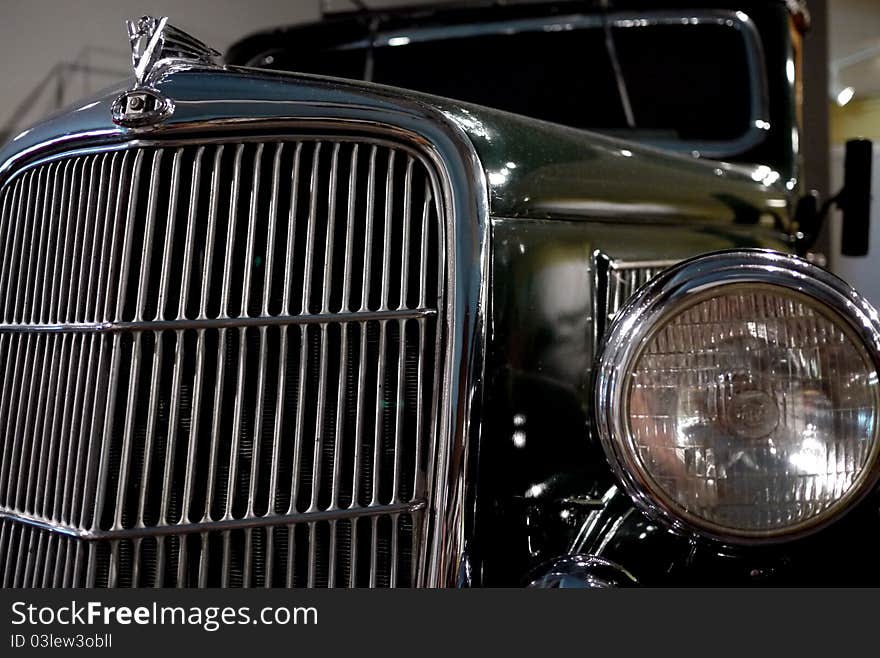 Classic car showing off its chrome grill, headlight and hood ornament. Classic car showing off its chrome grill, headlight and hood ornament