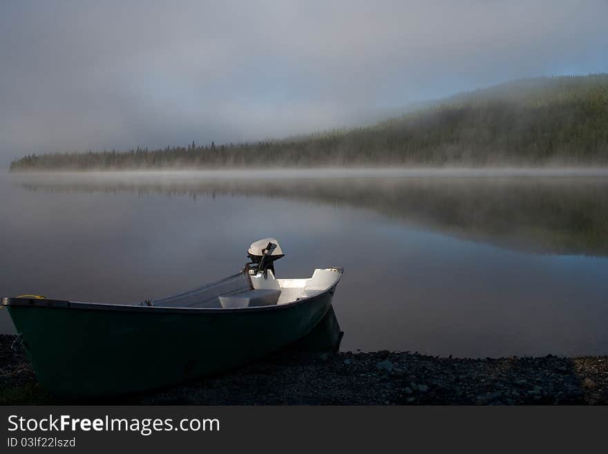 Boat on a misty lake in the morning. Cascapedia lake in Gaspesie, Quebec, Canada