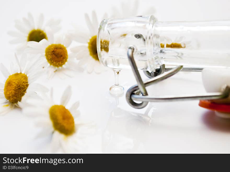 Butter flows from a bottle on a background camomiles. Butter flows from a bottle on a background camomiles