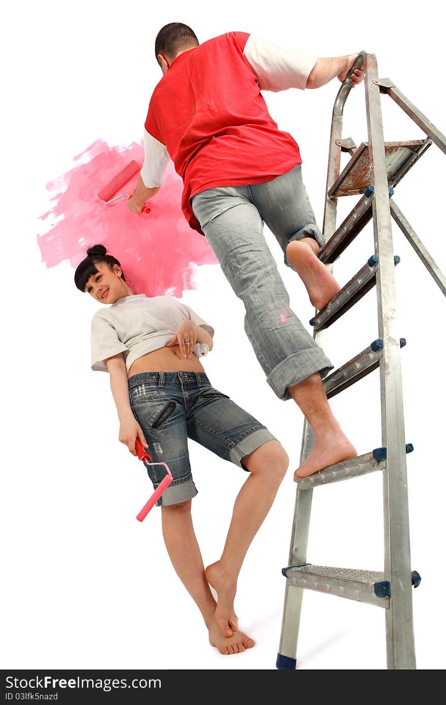 Cheerful young couple of workers preparing to painting a wal