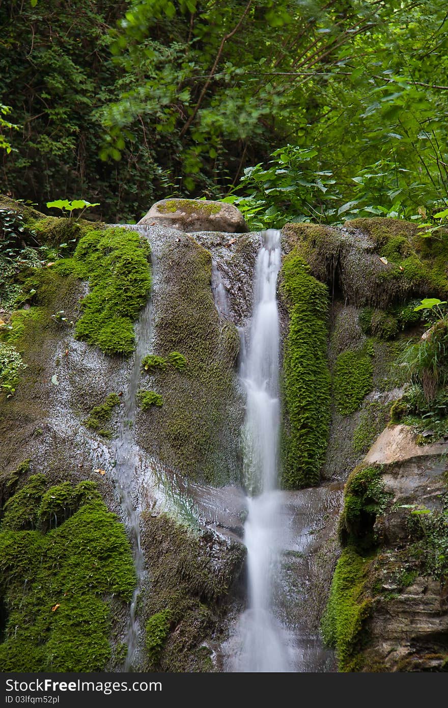 Waterfall from rock in green forest. Waterfall from rock in green forest