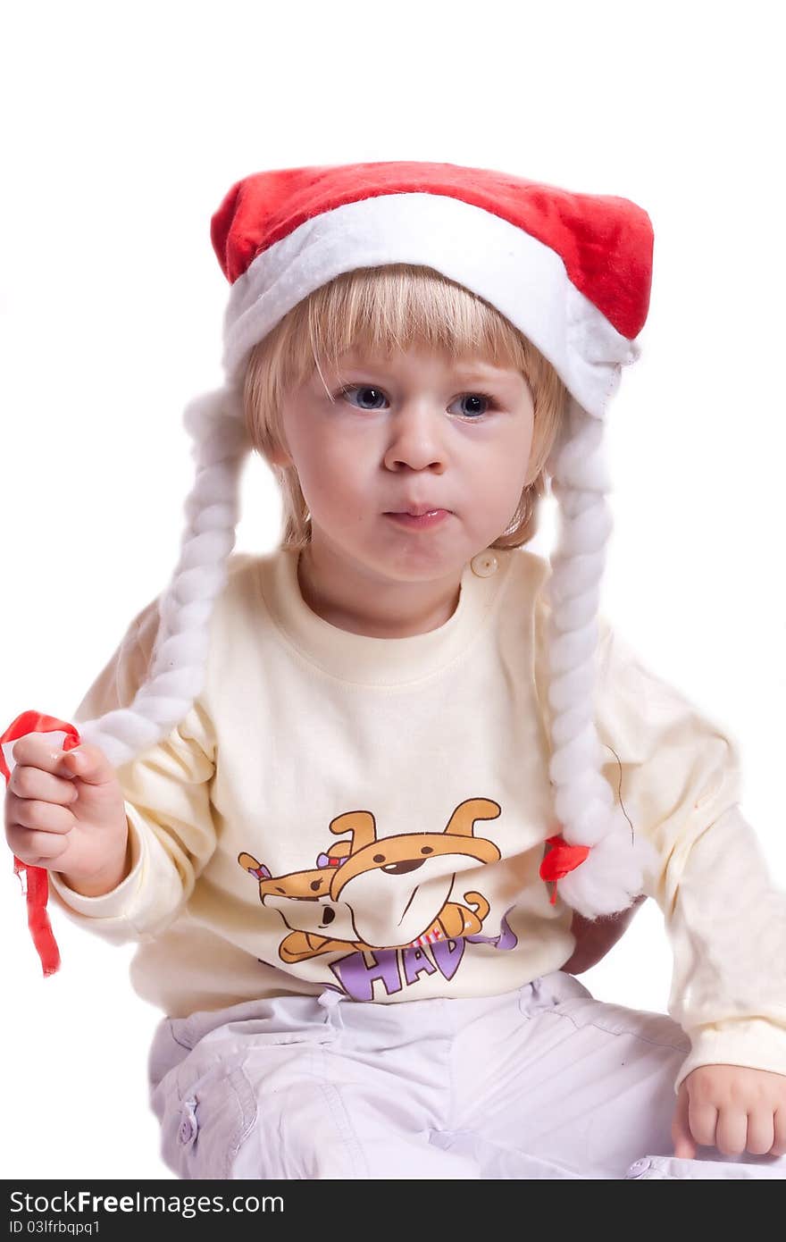 Little girl in a Christmas hat with braids on a white background