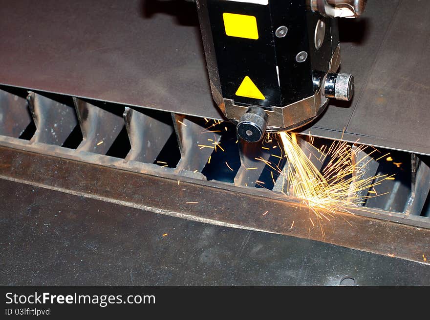 Photo of the industrial laser with sparks flying around. Photo of the industrial laser with sparks flying around