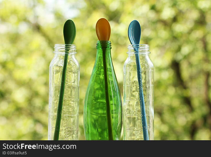 Colored glass bottles with colored spoon inside