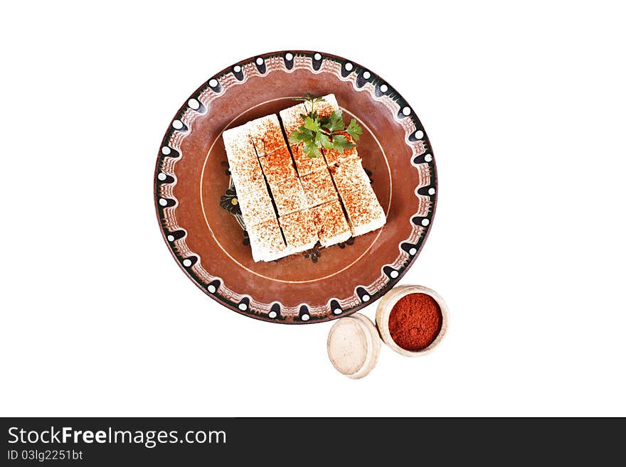 Bulgarian white cheese with paprika into a plate isolated on white. Bulgarian white cheese with paprika into a plate isolated on white