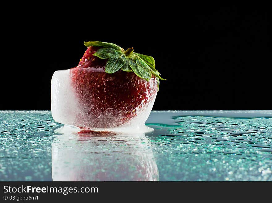 Strawberry in an ice cube on base of bathed plexiglass of drops. Strawberry in an ice cube on base of bathed plexiglass of drops