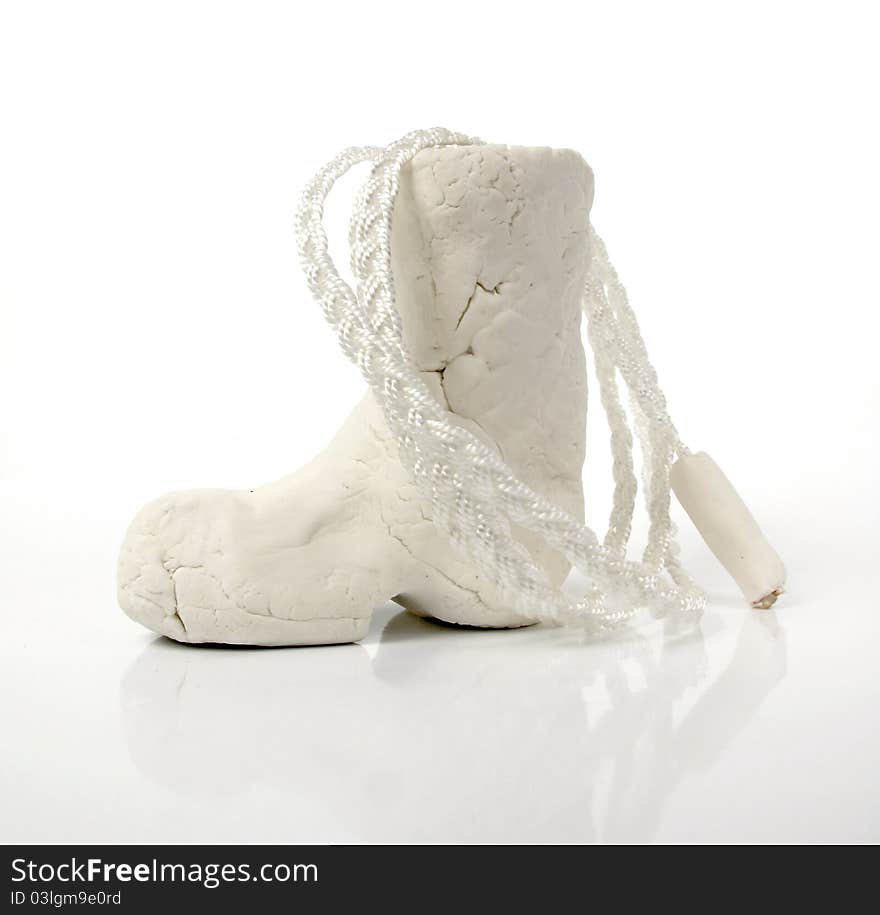 Primitive cowboy boot in white clay with a lariat. Primitive cowboy boot in white clay with a lariat