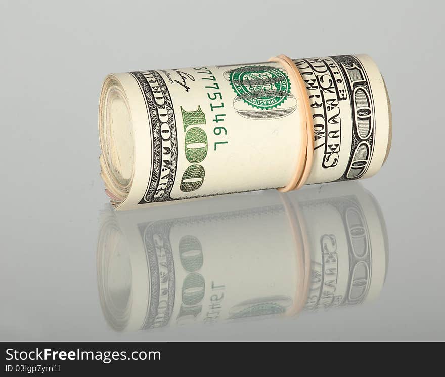 Bundle of dollar banknotes isolated on grey with reflection. Bundle of dollar banknotes isolated on grey with reflection