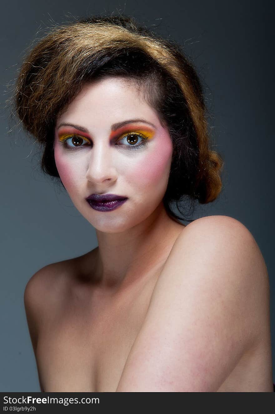 Beautiful young female against Grey with colourful make up