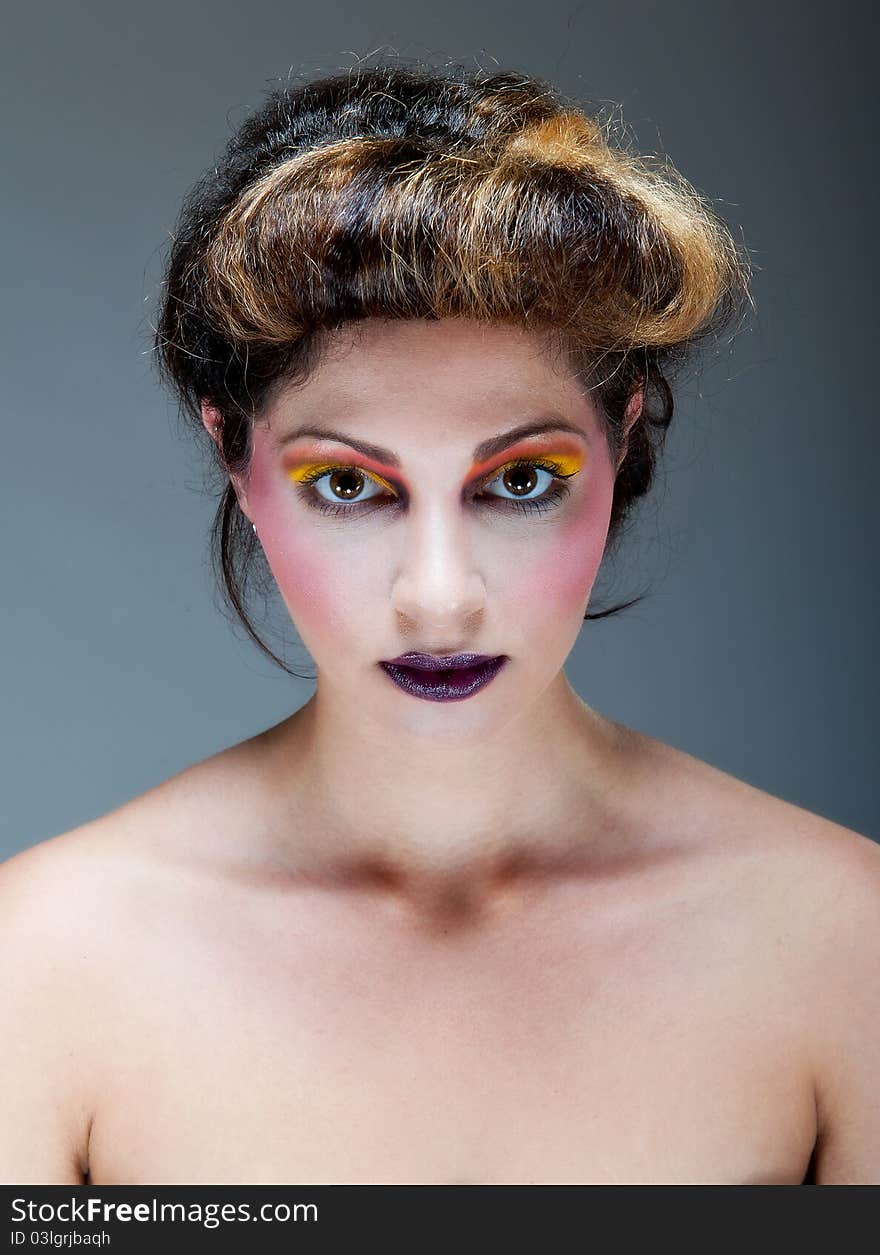 Female against grey with colourful make up