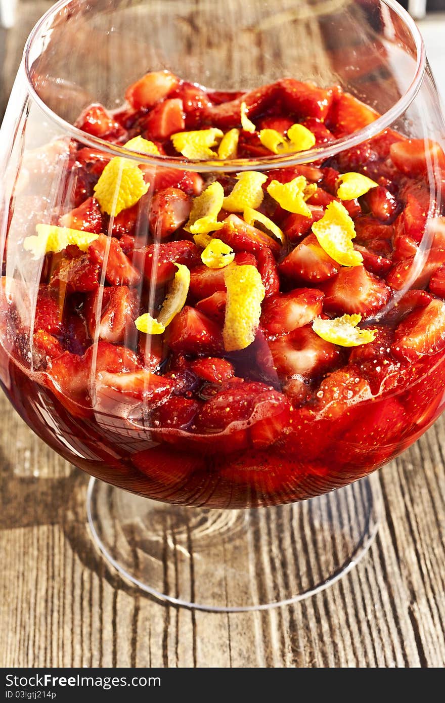 Strawberry jam with lemon zest in a transparent bowl