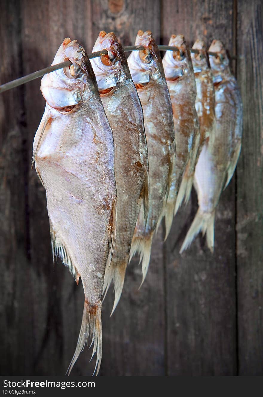 Bunch of salted fish on a wooden wall backdrop