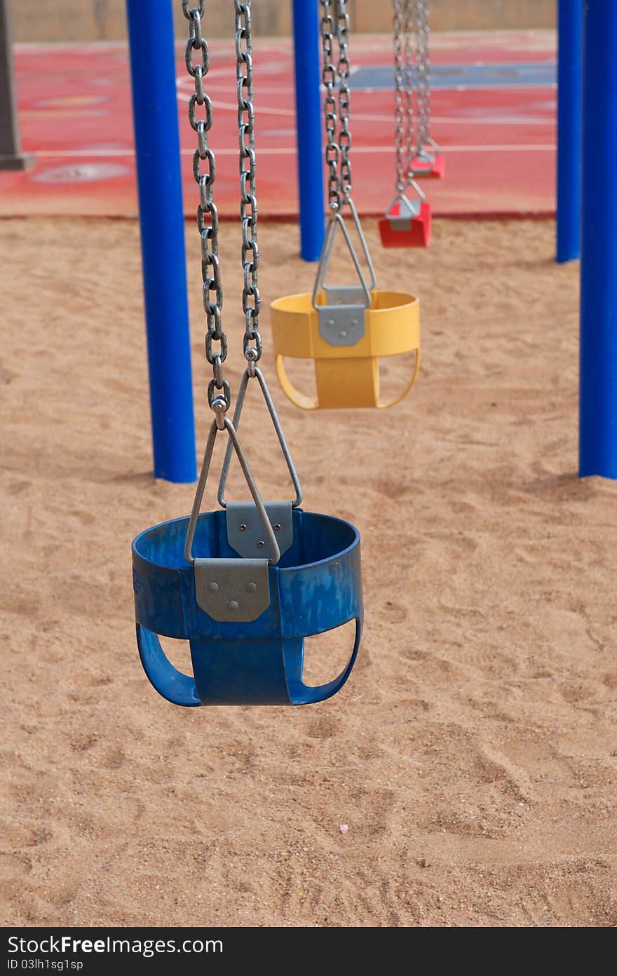 Colorful Empty Swings in Sand