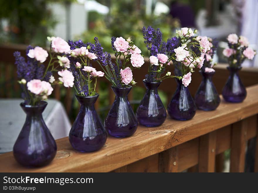 Rose and lavender in purple vases. Rose and lavender in purple vases