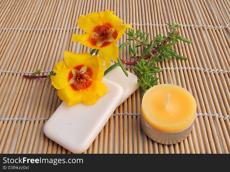 Candle and soap on bamboo background