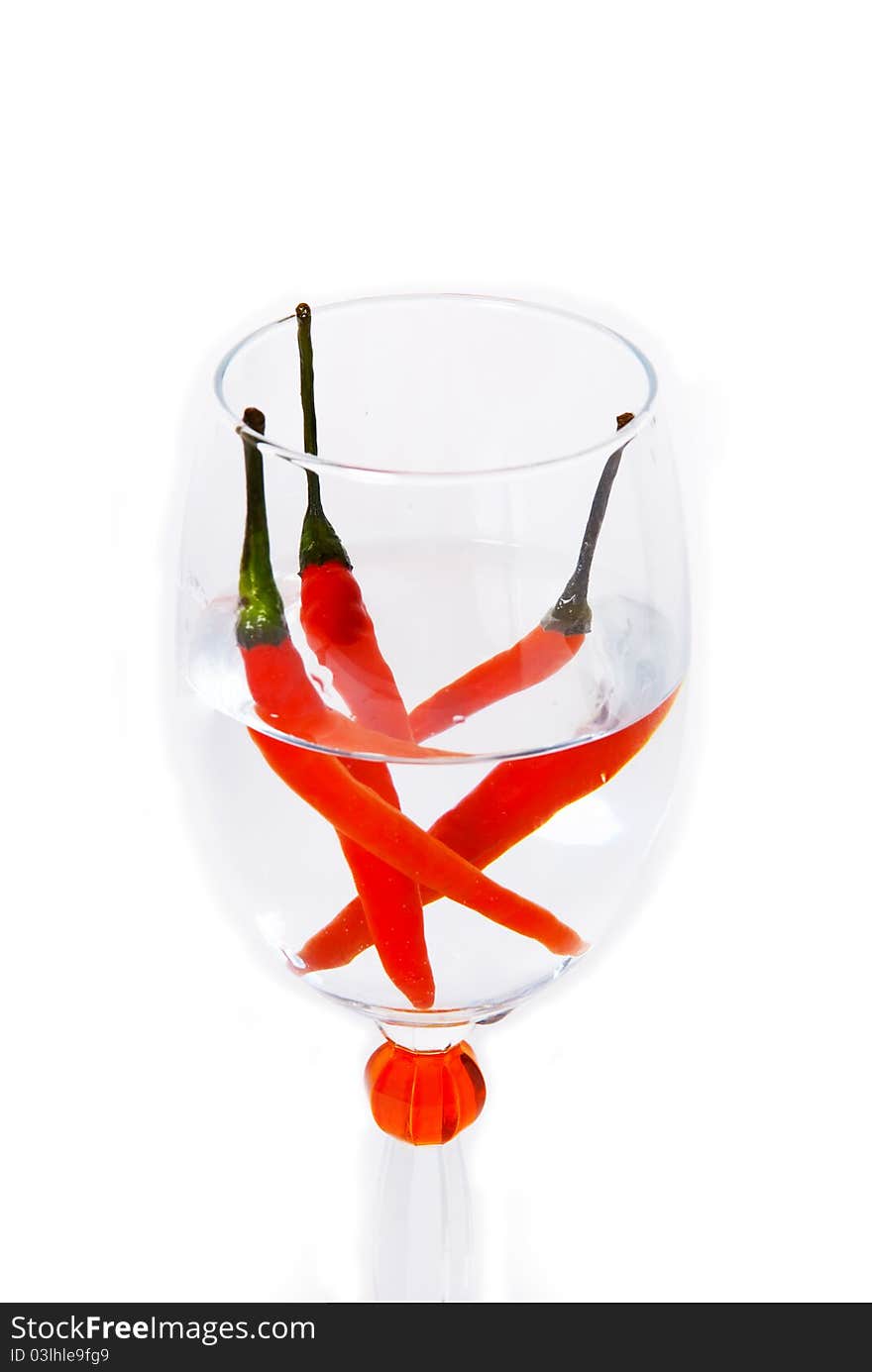 Three red Chillies in a glass of water.