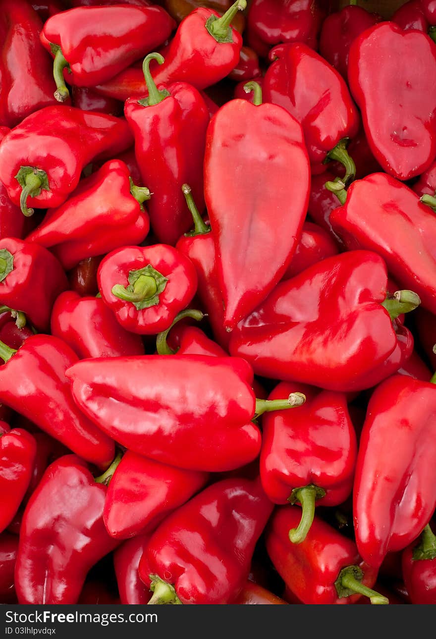 Background of many big red peppers, vertical photo