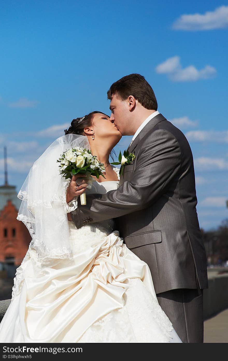 Romantic kiss bride and groom on wedding walk