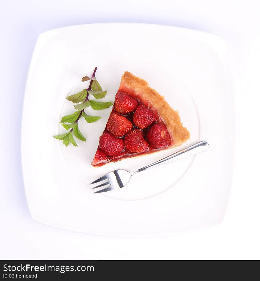 Strawberry Tart on white plate decorated with mint twig