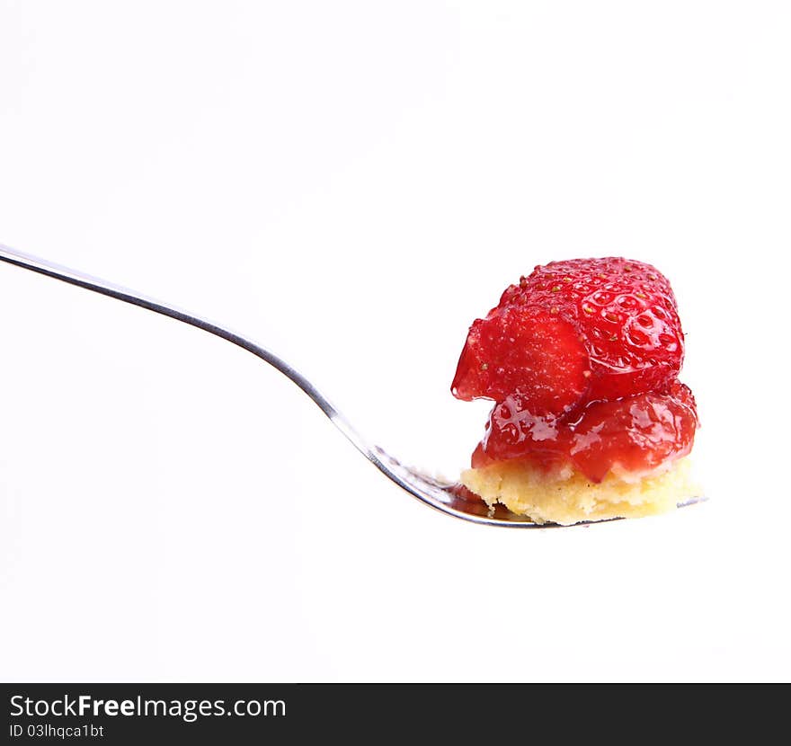 Piece of Strawberry Tart on a fork on a white background