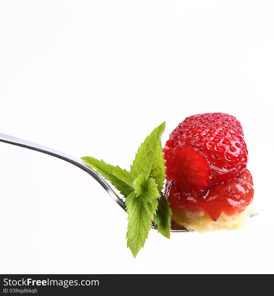 Piece of Strawberry Tart on a fork decorated with mint twig