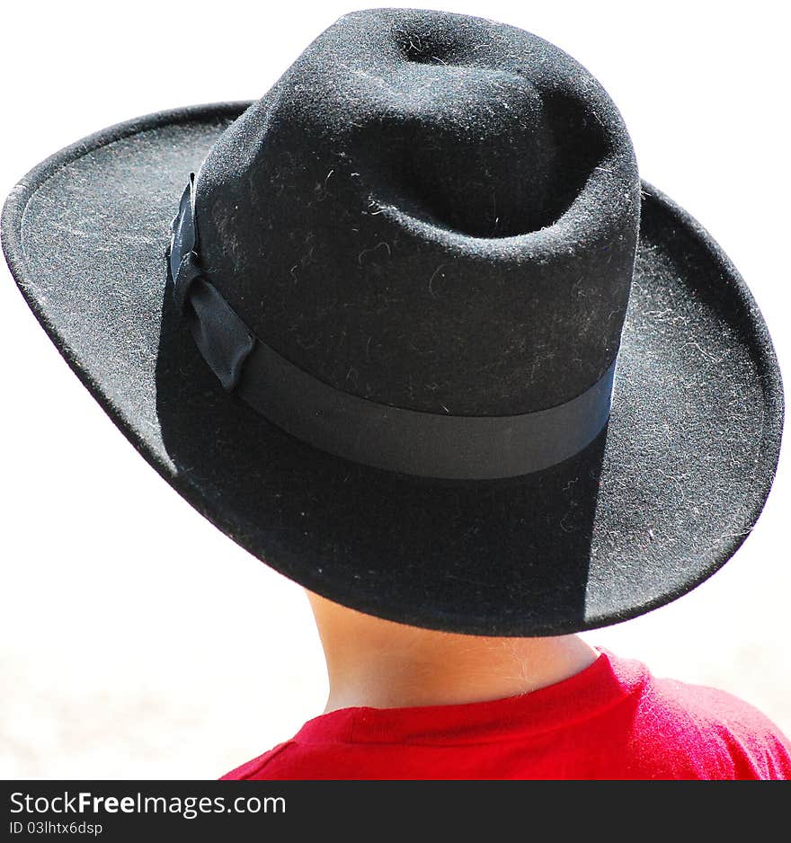 Young cowboy stands watching the local rodeo parade. Young cowboy stands watching the local rodeo parade.