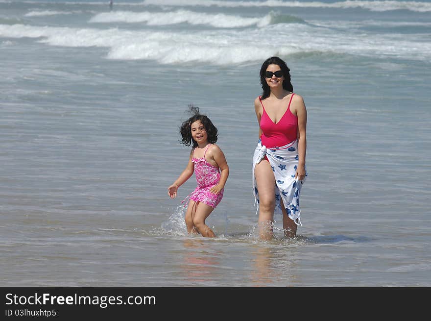 Mother and her baby in the beach near the water