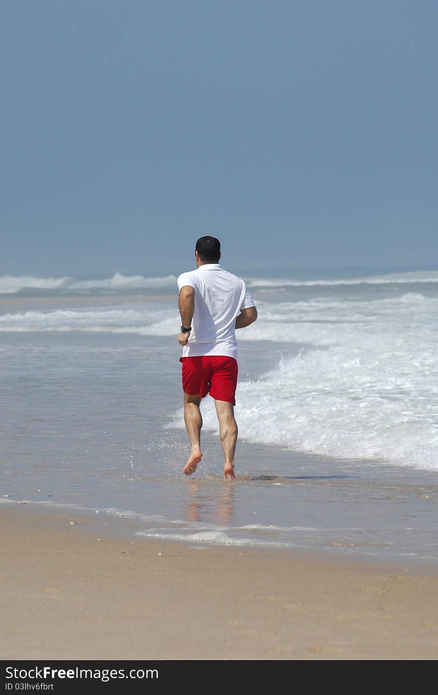 Middle age man running full of energy on the beach