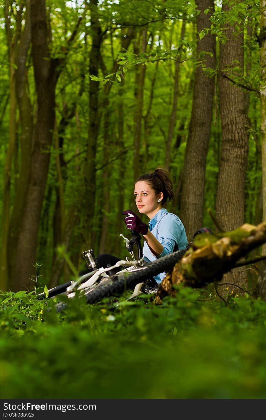 Young, beautiful woman sitting with bicycle. Young, beautiful woman sitting with bicycle