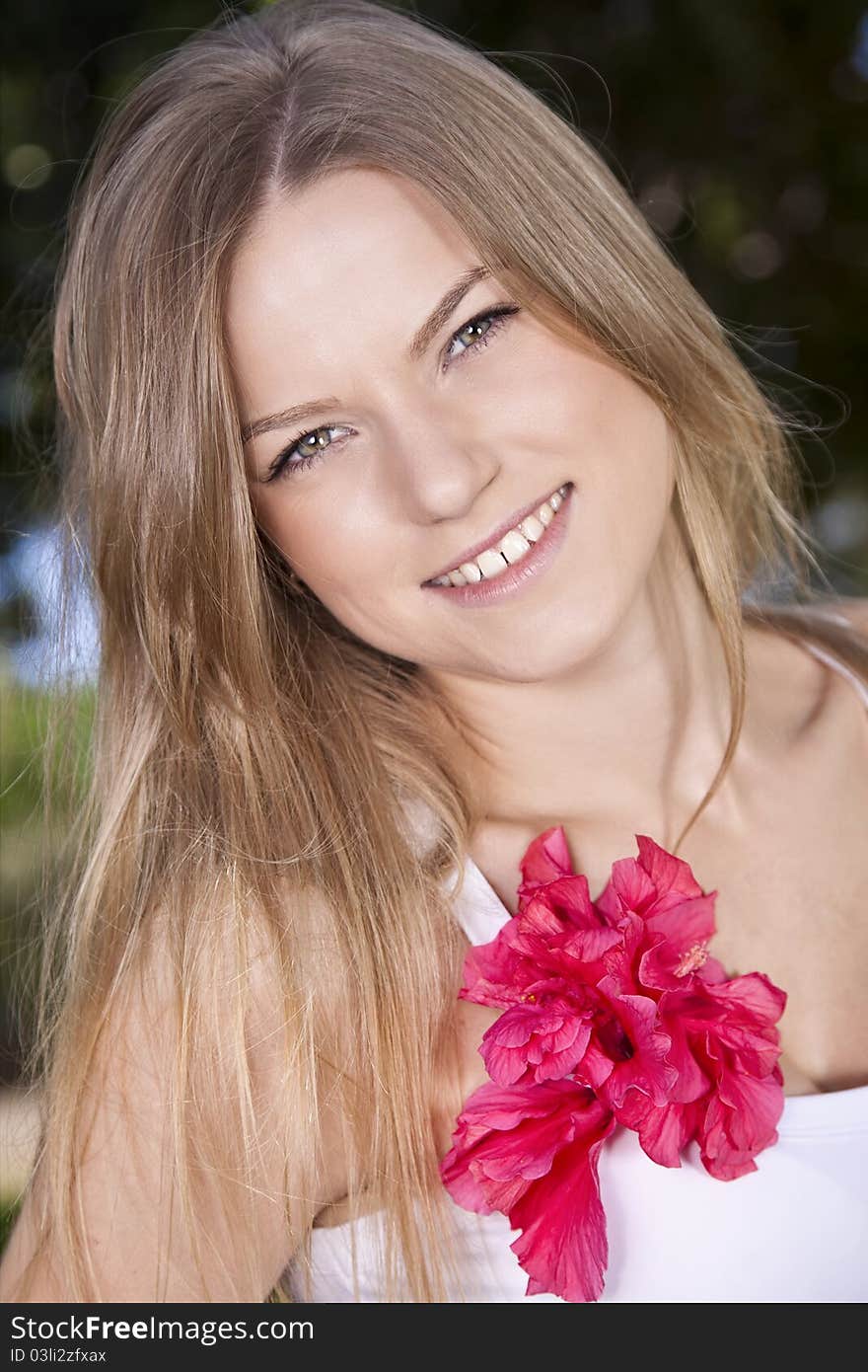 Portrait of a beauty blonde girl with red flower