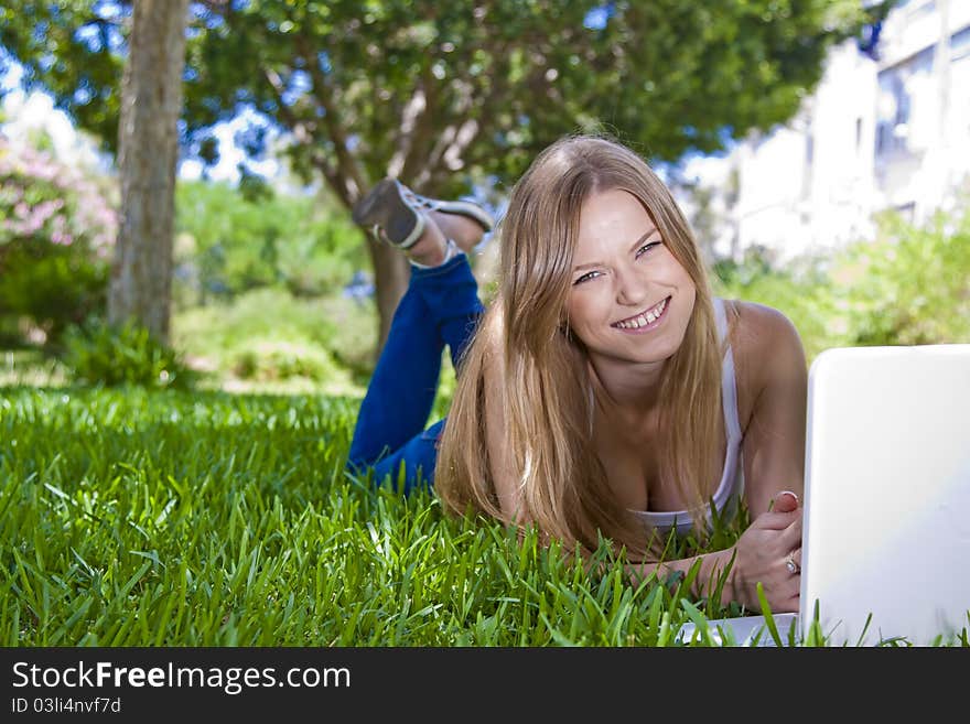 Beauty blonde girl studying outdoor with laptop and posing for shot. Beauty blonde girl studying outdoor with laptop and posing for shot