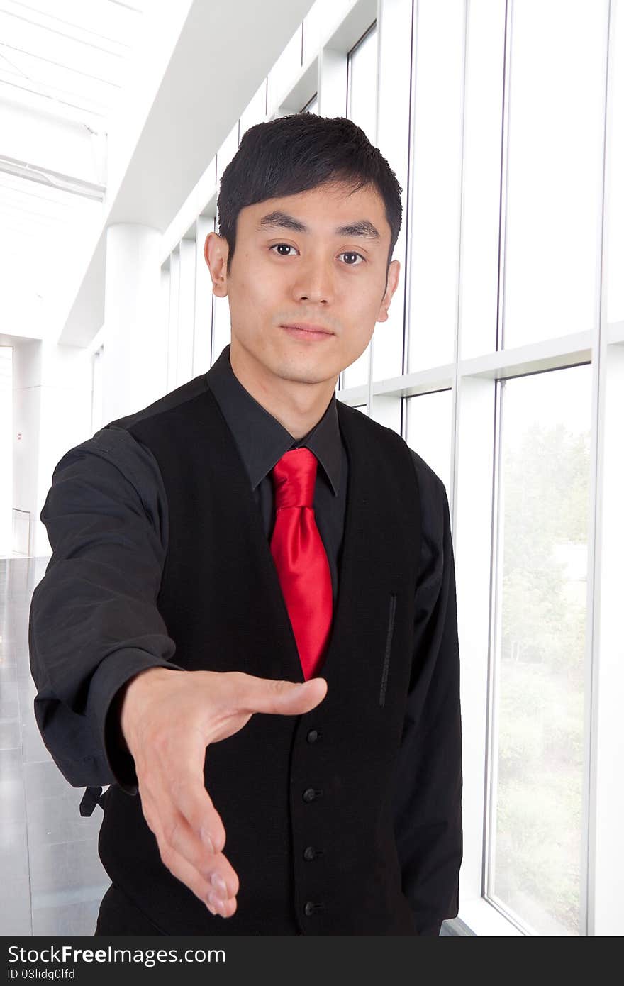 Hip young Asian man with hand out at the airport. Hip young Asian man with hand out at the airport